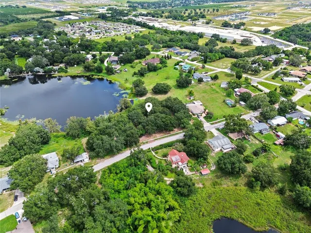 an aerial view of residential houses with outdoor space and trees