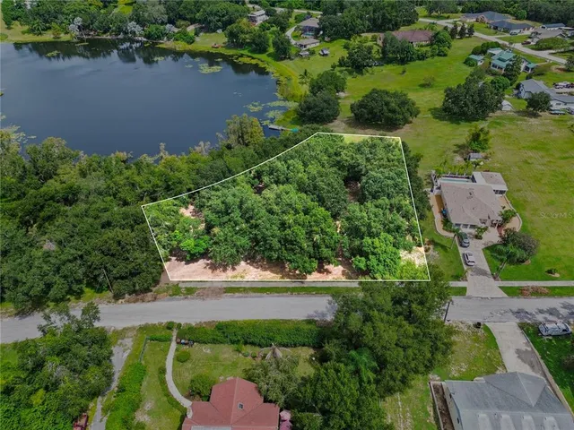 an aerial view of a house with outdoor space and lake view