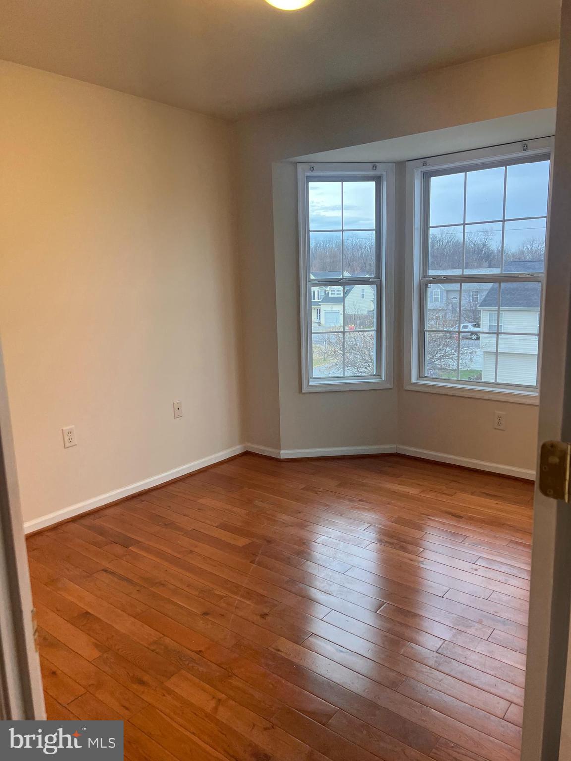 121 North Marshall Street Ranson, WV 25438 - Photo 12 of 17 an empty room with wooden floor and windows