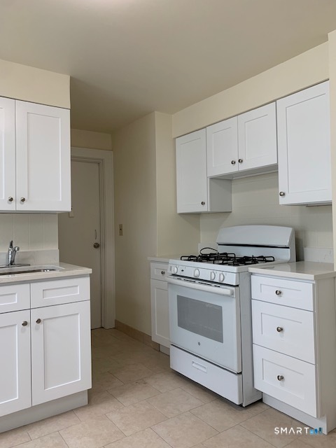 18 Lawrence Street Norwalk, CT 06854 - Photo 9 of 31 a kitchen with white cabinets and white appliances