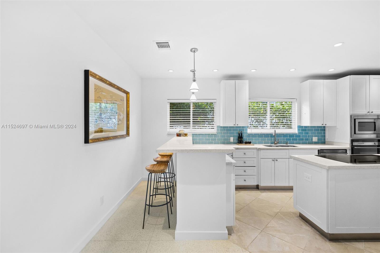 1310 Cleveland Road Miami Beach, FL 33141 - Photo 6 of 33 a kitchen with white cabinets and window