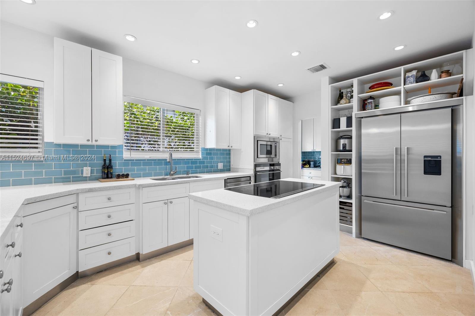 1310 Cleveland Road Miami Beach, FL 33141 - Photo 7 of 33 a kitchen with white cabinets and stainless steel appliances