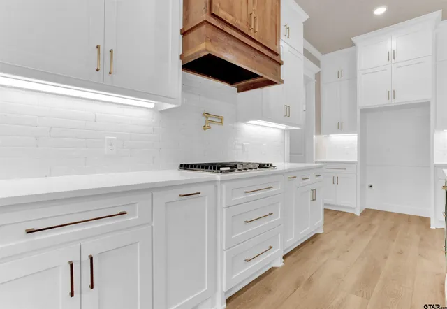 a kitchen with white cabinets and appliances