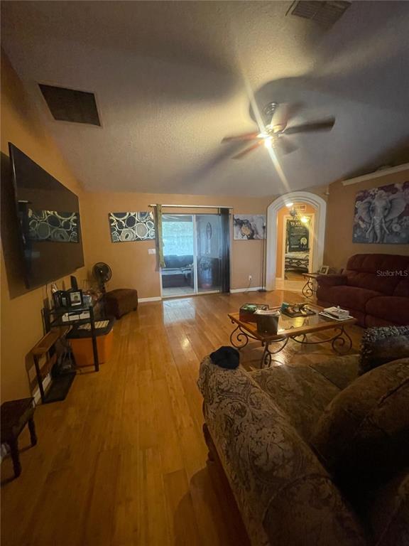 396 Kettering Road Deltona, FL 32725 - Photo 7 of 25 a living room with furniture a flat screen tv and a large window