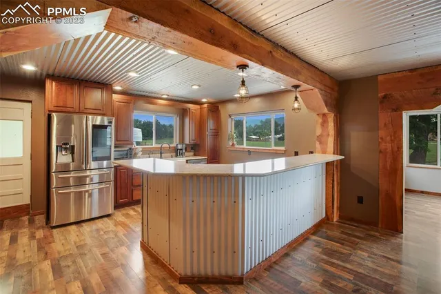 a kitchen with stainless steel appliances kitchen island granite countertop a refrigerator a sink and a stove