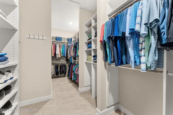 a view of walk in closet with clothes