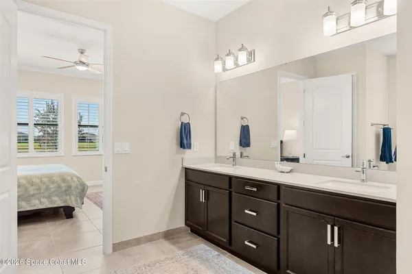 a en suite bathroom with double vanity a sink a large mirror and vanity
