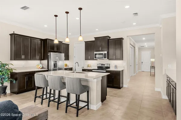 a kitchen with stainless steel appliances kitchen island granite countertop a stove a sink a dining table and chairs with wooden floor