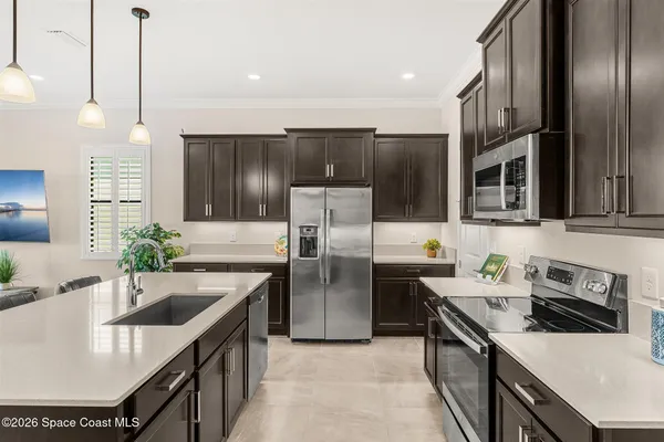 a kitchen with stainless steel appliances granite countertop a sink a stove and a refrigerator