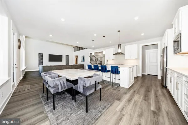 a large kitchen with stainless steel appliances kitchen island a large counter top and a wooden floors