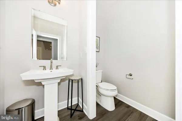 a large white bathroom with a granite countertop sink a large mirror and a bathtub