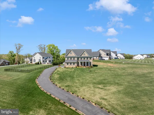 an aerial view of a house with a garden and lake view