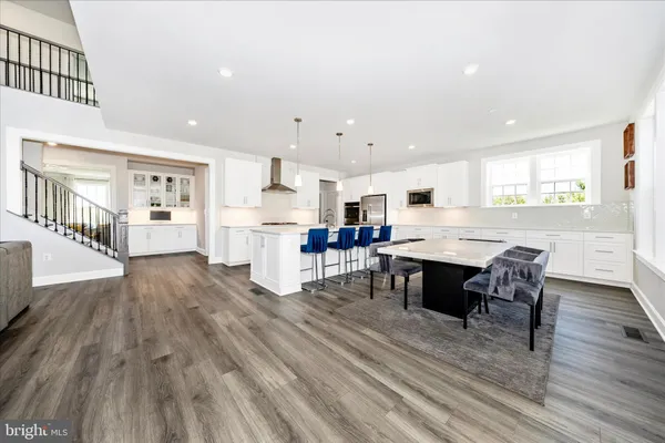 a large kitchen with stainless steel appliances lots of counter space and wooden floor