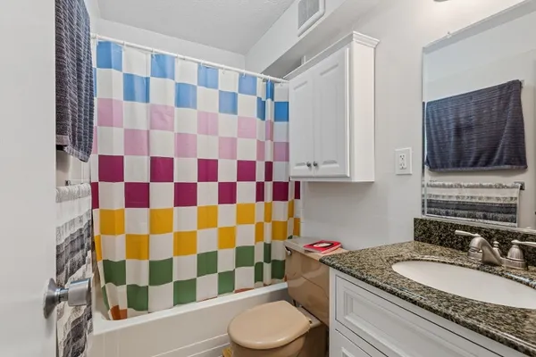 a bathroom with a sink toilet a mirror and shower curtain