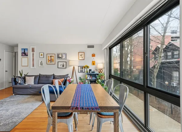 a dining room with furniture a rug and a large window