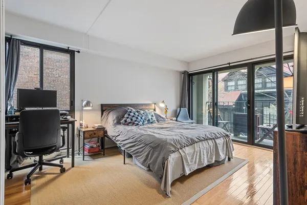 a bedroom with a bed and large windows