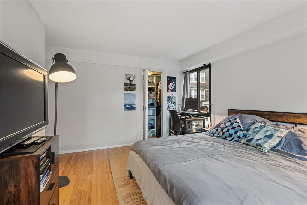 55 Sewall Avenue, Unit 1C Brookline, MA 02446 - Photo 8 of 16 a bedroom with a large bed and a flat tv screen on a dresser