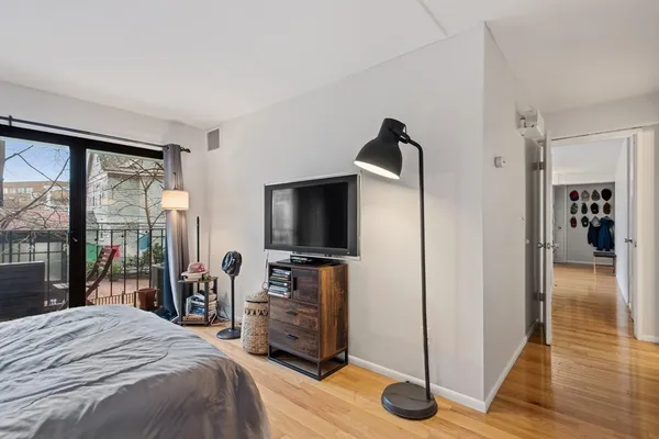 a bedroom with a bed and a flat tv screen next to a window