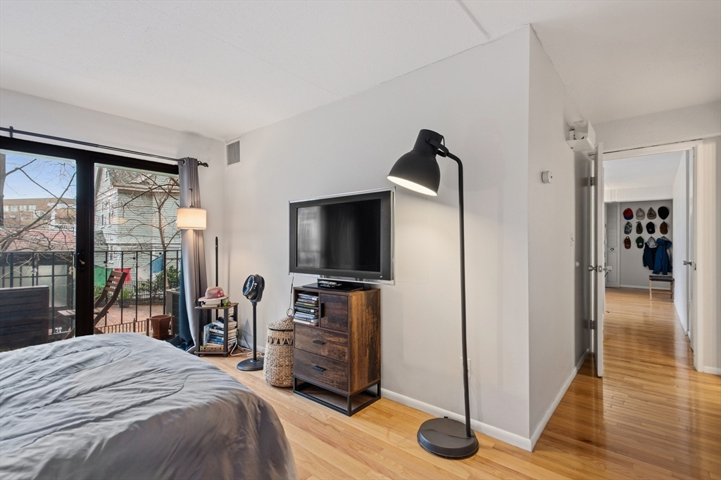 55 Sewall Avenue, Unit 1C Brookline, MA 02446 - Photo 9 of 16 a bedroom with a bed and a flat tv screen next to a window