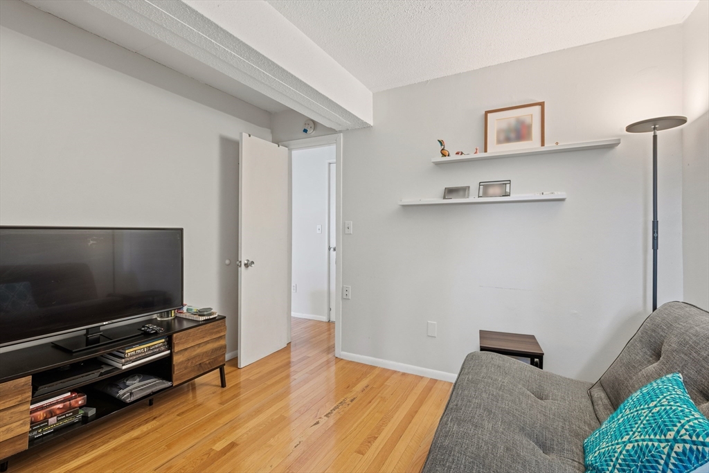 55 Sewall Avenue, Unit 1C Brookline, MA 02446 - Photo 10 of 16 a living room with furniture and a flat screen tv