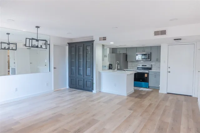 a kitchen with stainless steel appliances kitchen island a refrigerator sink and cabinets