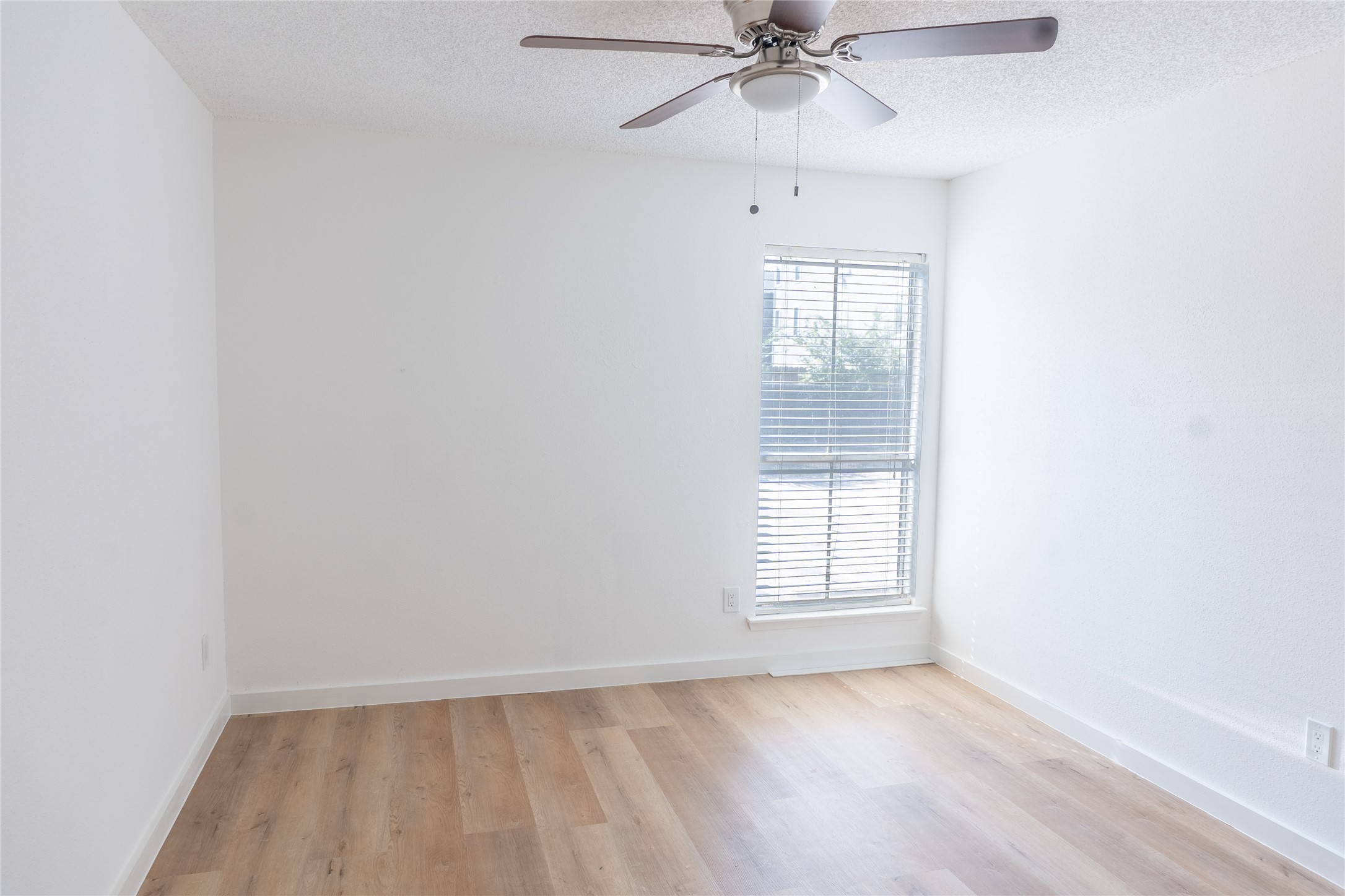 3919 Fairmont Parkway, Unit 129 Pasadena, TX 77504 - Photo 9 of 18 an empty room with wooden floor fan and windows