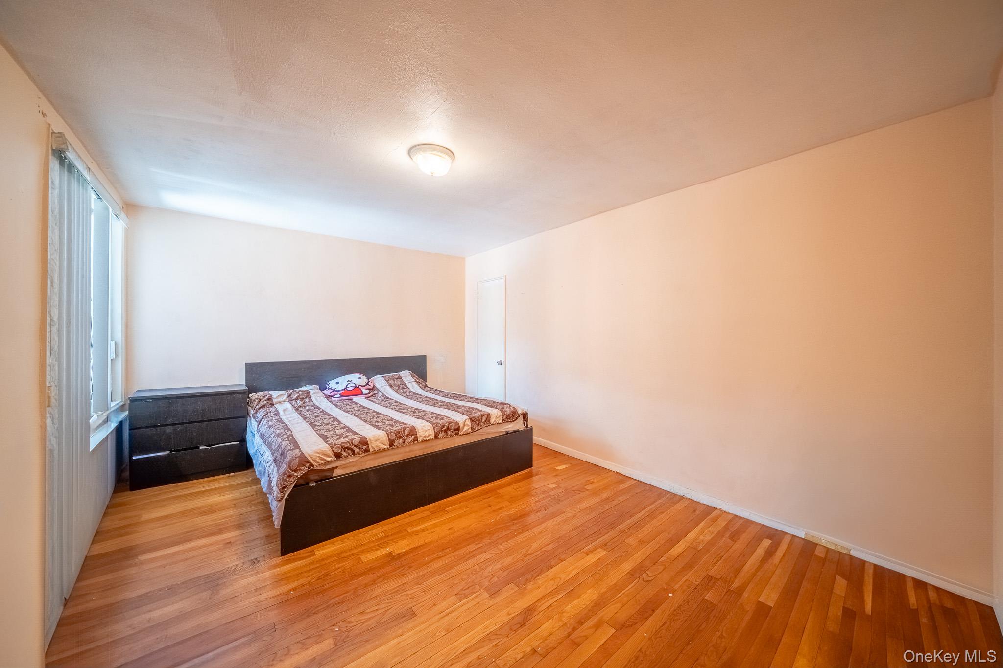 108-49 63rd Avenue, Unit 4A Queens, NY 11375 - Photo 4 of 10 a bedroom with a bed and a window