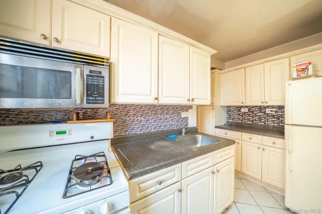 a kitchen with granite countertop a sink and a stove top oven