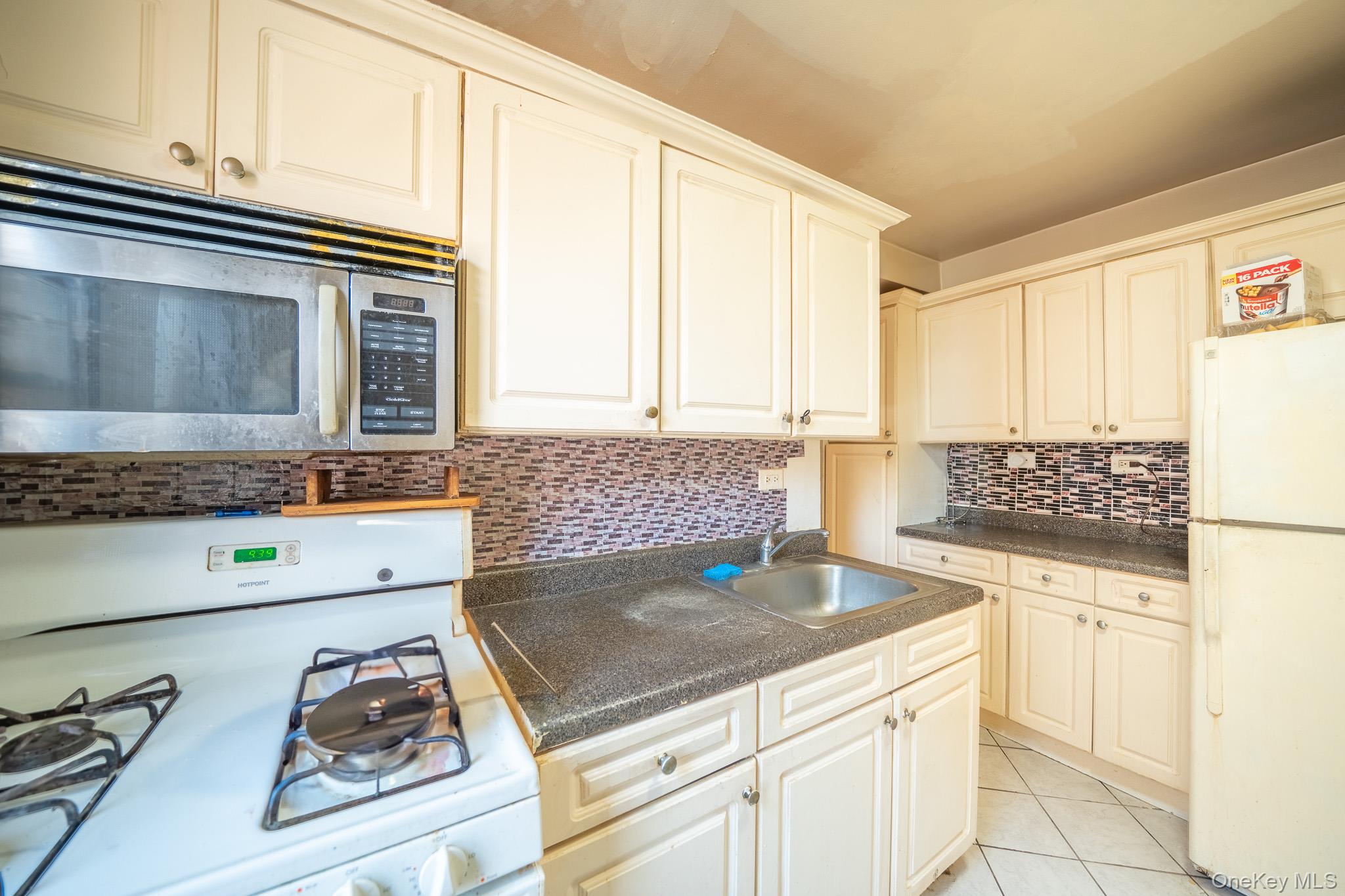 108-49 63rd Avenue, Unit 4A Queens, NY 11375 - Photo 7 of 10 a kitchen with granite countertop a sink and a stove top oven
