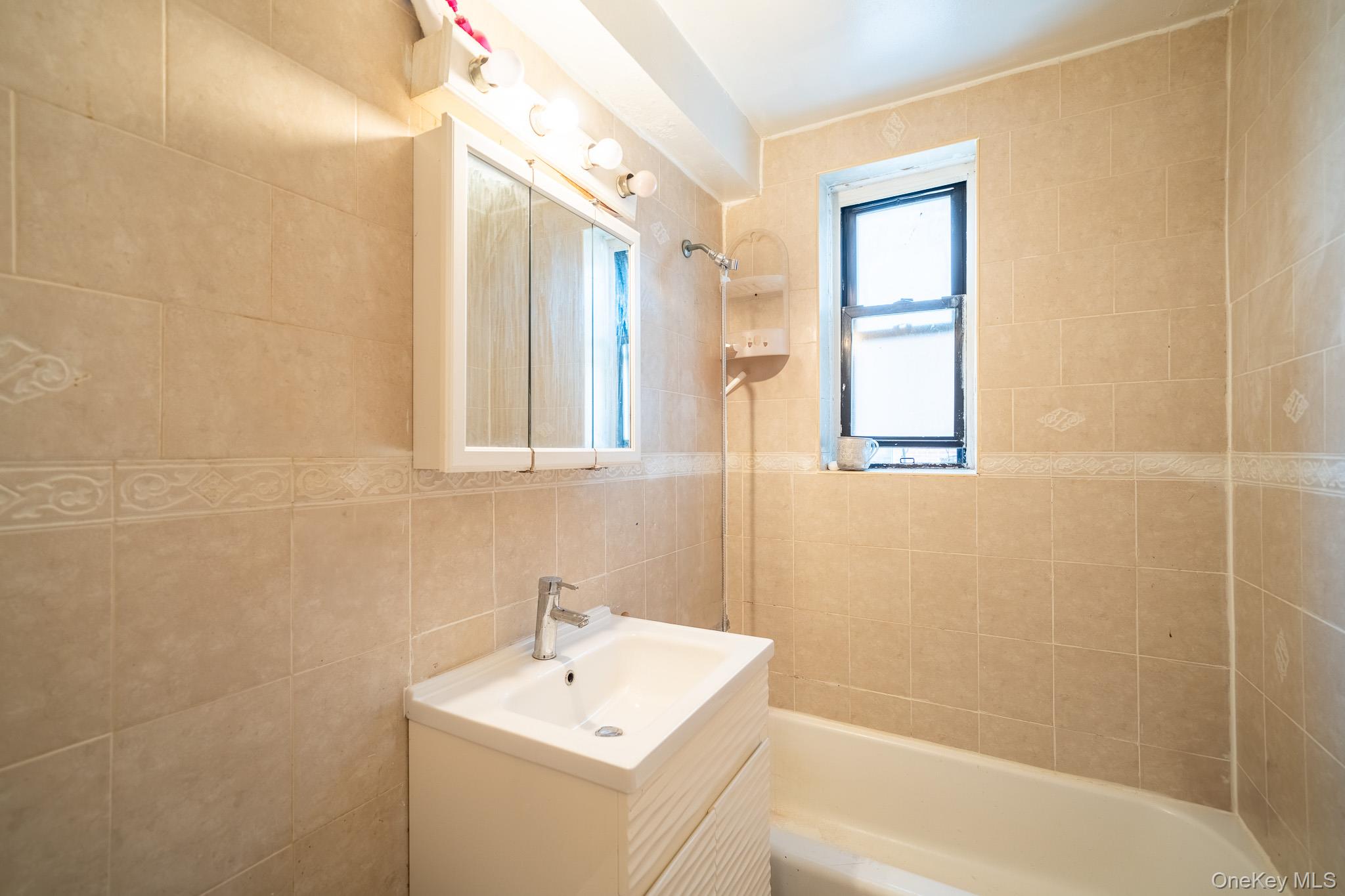 108-49 63rd Avenue, Unit 4A Queens, NY 11375 - Photo 8 of 10 a bathroom with a sink a toilet and shower