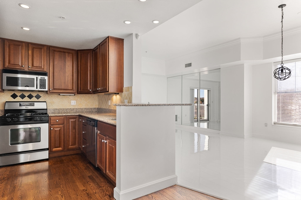 a kitchen with stainless steel appliances granite countertop a refrigerator and a stove top oven