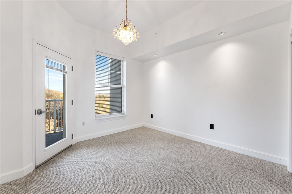 36 Village Road, Unit 715 Middleton, MA 01949 - Photo 20 of 32 en empty room with windows and chandelier