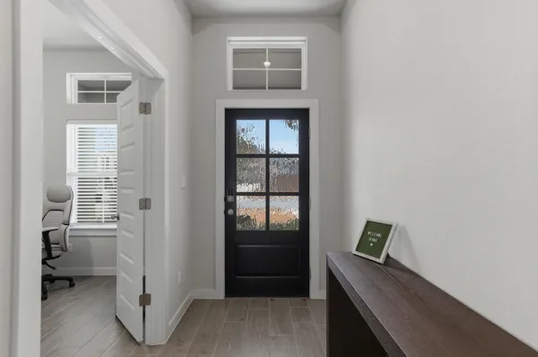 a view of a hallway with bathroom and wooden floor