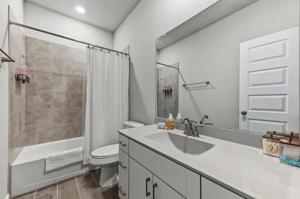 a bathroom with a sink toilet double vanity and shower