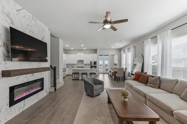 a living room with furniture a flat screen tv and a fireplace