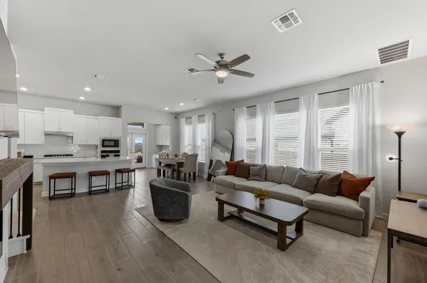 a living room with furniture kitchen view and a large window