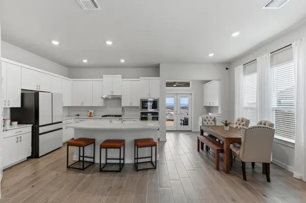 a large kitchen with kitchen island a dining table and chairs