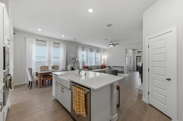 a large kitchen with kitchen island a sink a stove a dining table and chairs