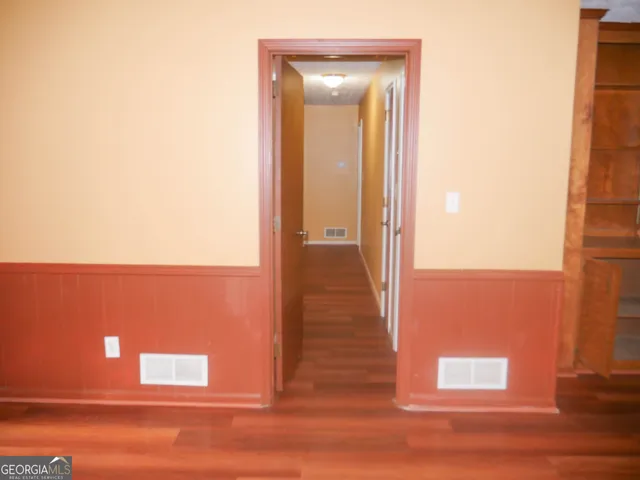 a view of storage and utility room with wooden floor and windows