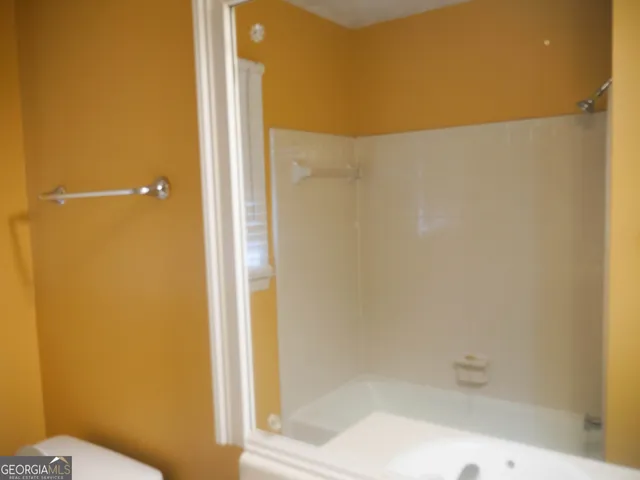 a bathroom with a toilet and a shower