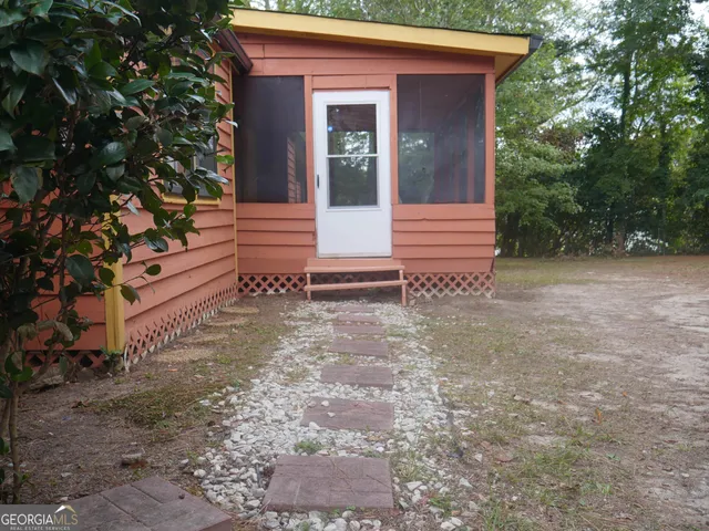 a view of a house with backyard and a tree