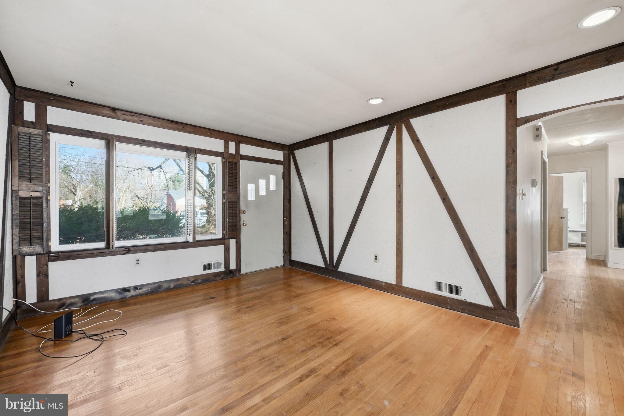 703 Northwest Drive Silver Spring, MD 20901 - Photo 2 of 25 a view of an empty room with wooden floor and a window