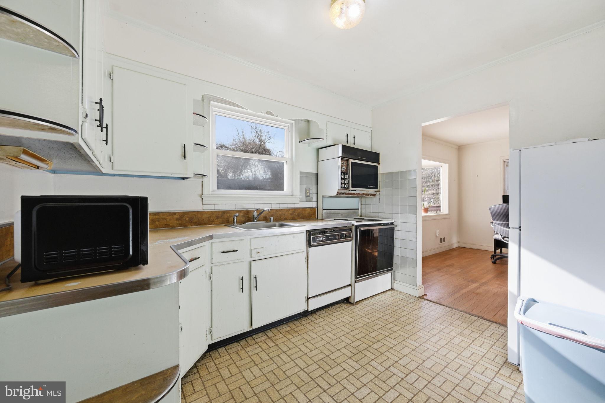 703 Northwest Drive Silver Spring, MD 20901 - Photo 5 of 25 a large kitchen with a stove and a sink