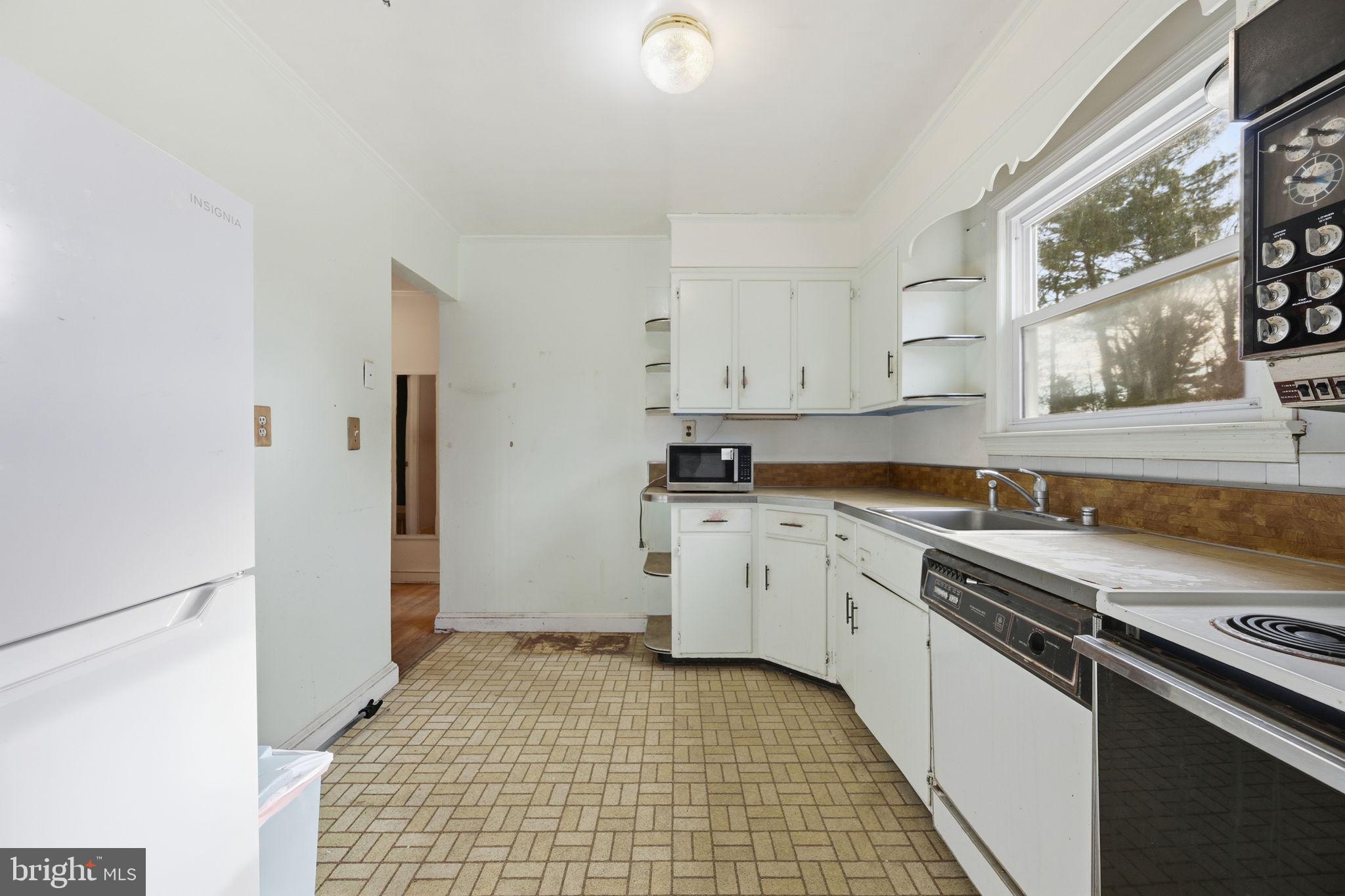 703 Northwest Drive Silver Spring, MD 20901 - Photo 6 of 25 a kitchen with granite countertop white cabinets and stainless steel appliances