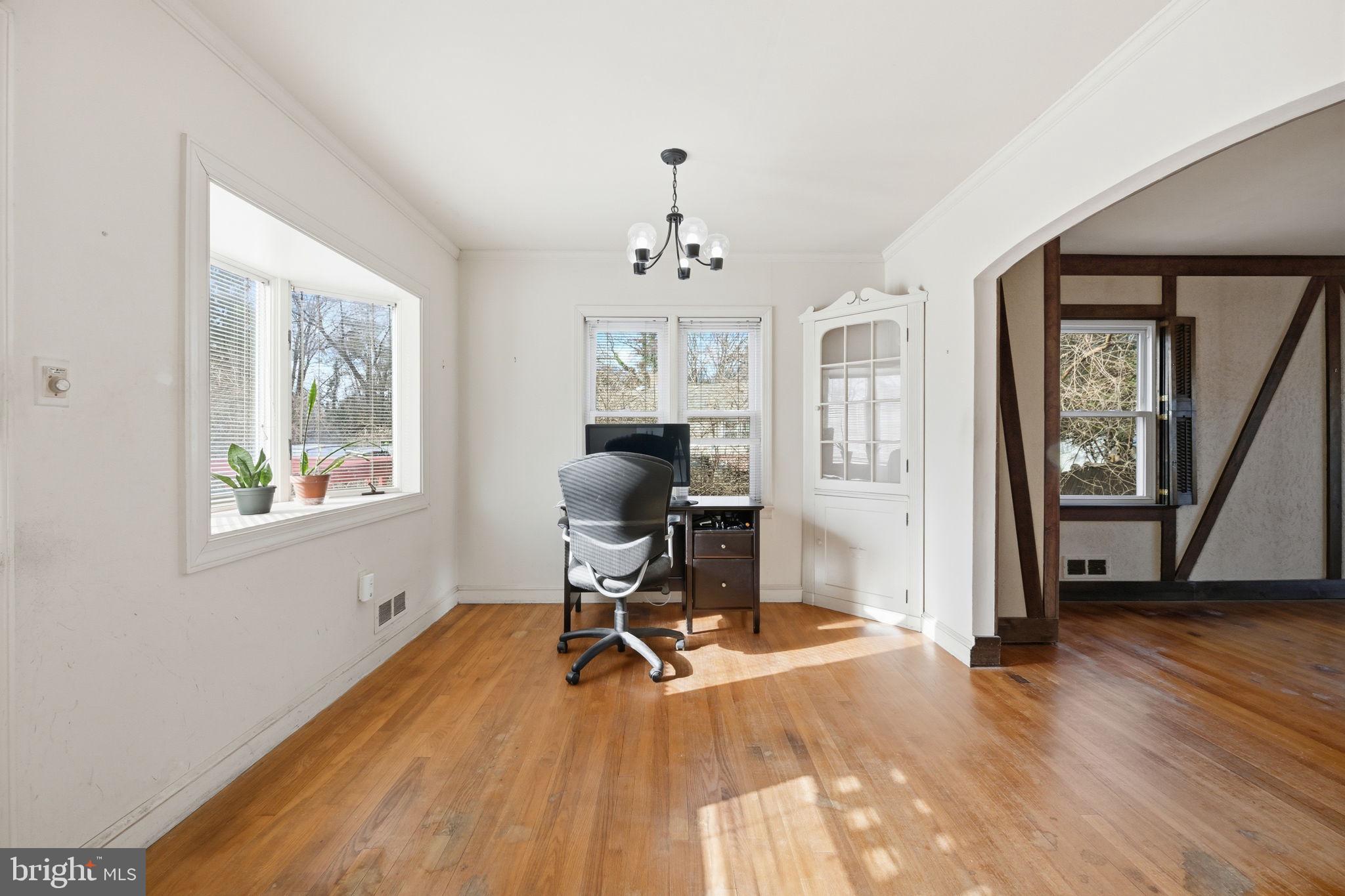 703 Northwest Drive Silver Spring, MD 20901 - Photo 7 of 25 a view of a workspace with wooden floor and windows