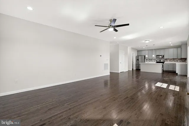 an empty room with a ceiling fan and a window