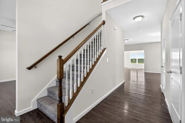 a view of an empty room and chandelier fan