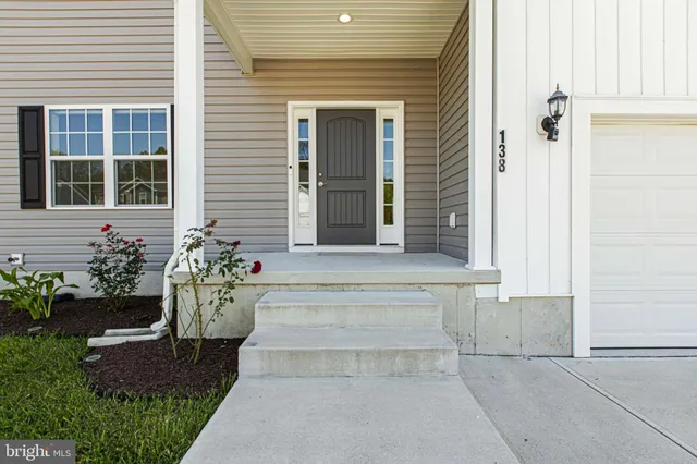 an empty room with wooden floor ceiling fan and window