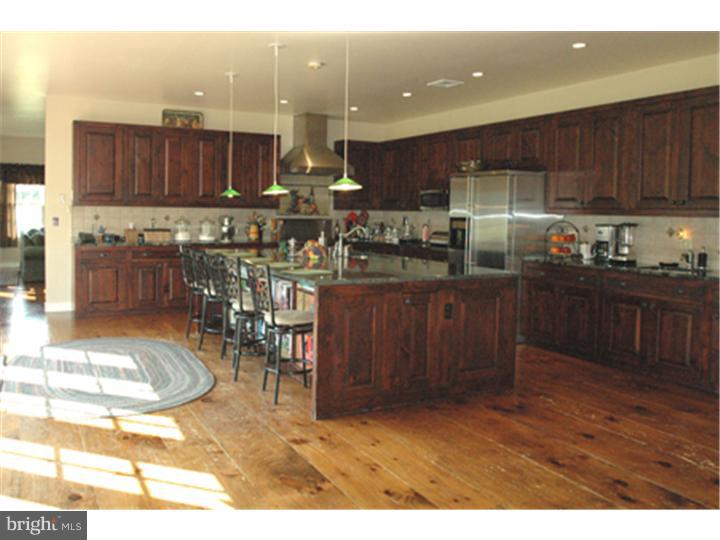 2652 North Sugan Road New Hope, PA 18938 - Photo 8 of 12 a kitchen with stainless steel appliances granite countertop a table chairs and a refrigerator