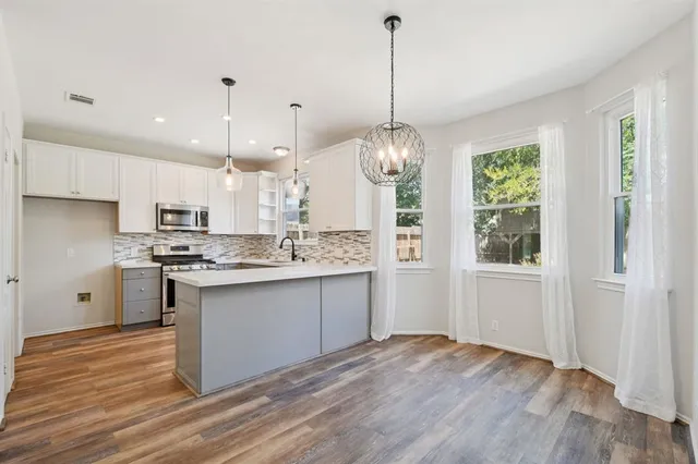 a kitchen with a sink stove and cabinets